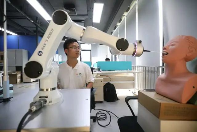 珠海澳科大科技研究院工作人員正在研究用于自動(dòng)核酸采樣的機(jī)器人。 圖片