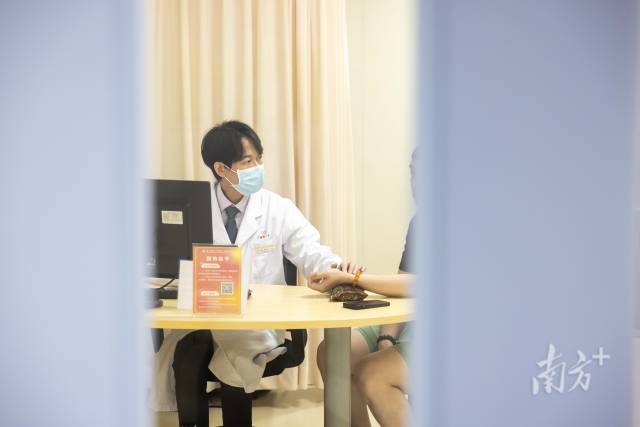 梁偉衡在給病人看診。