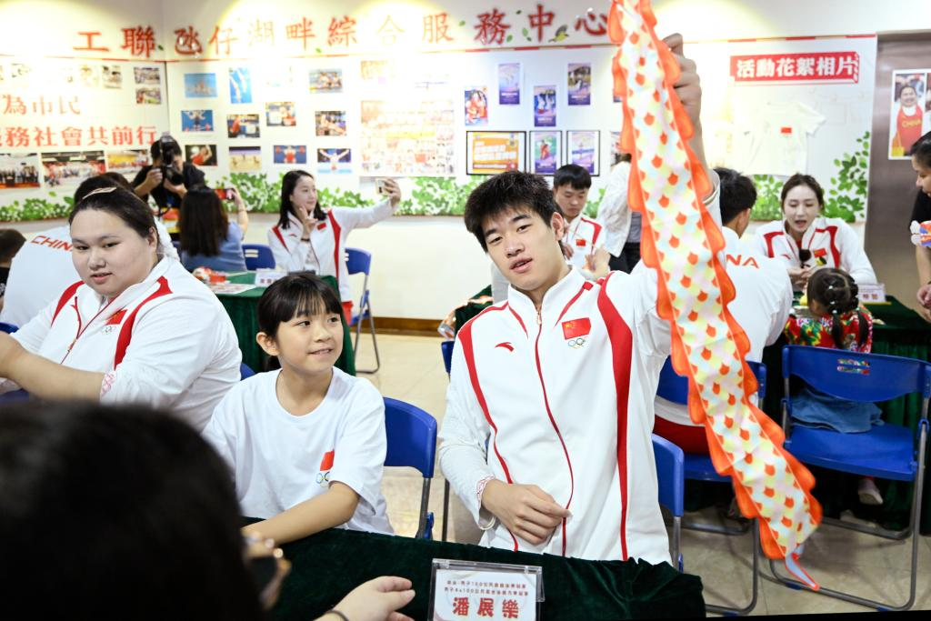 9月2日，在澳門工聯氹仔湖畔綜合服務中心，游泳運動員潘展樂（右）展示與小朋友一起制作的燈籠。當日，內地奧運健兒代表團走進澳門社區，分別到婦聯樂滿家庭服務中心、街總石排灣家庭及社區綜合服務中心和工聯氹仔湖畔綜合服務中心與市民互動。新華社發