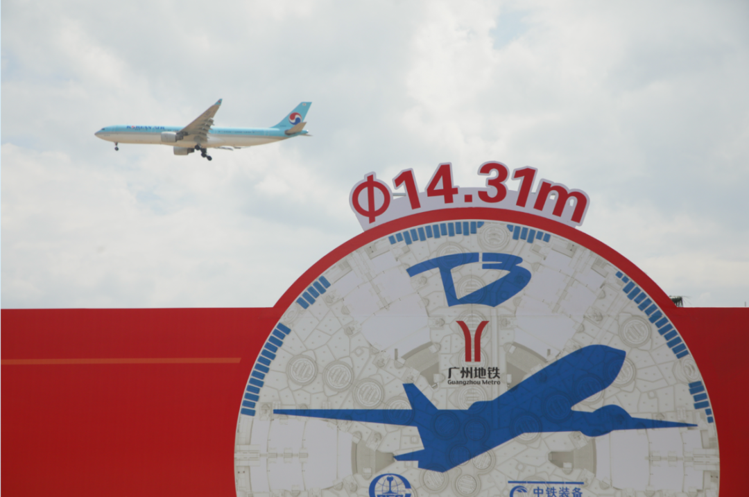 ▲飛機(jī)低空飛過工地上的14.31米的盾構(gòu)機(jī)標(biāo)志牌 ▲飛機(jī)低空飛過工地上的14.31米的盾構(gòu)機(jī)標(biāo)志牌