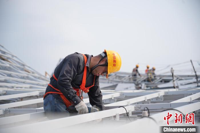 建設(shè)者們忙于幕墻工程、金屬屋面、機(jī)電安裝、精裝修施工。記者 韋杰夫 攝