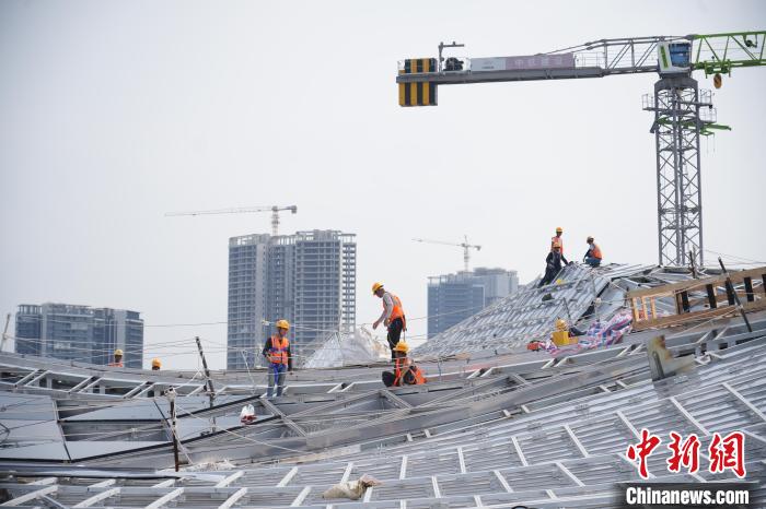 建設(shè)者們忙于幕墻工程、金屬屋面、機(jī)電安裝、精裝修施工。記者 韋杰夫 攝