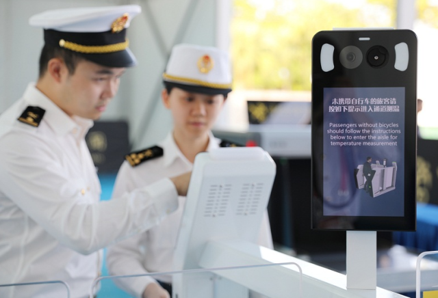 為迎接自行車（公路）賽男子個人賽（十五運會唯一跨越粵港澳三地的標志性賽事），拱北海關(guān)關(guān)員對體溫檢測閘機進行測試。來源：海關(guān)總署