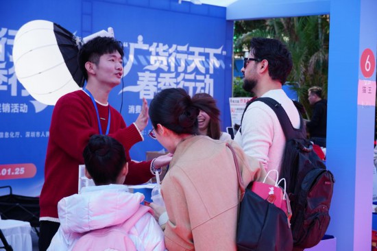 在“廣貨行天下”春季行動消費電子專場促銷活動現場，國外游客與商家交談。新華社記者 王豐 攝