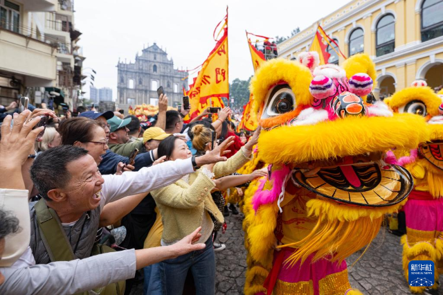 2月17日，舞獅隊伍在澳門大三巴牌坊前與市民互動。 新華社發（張金加攝）